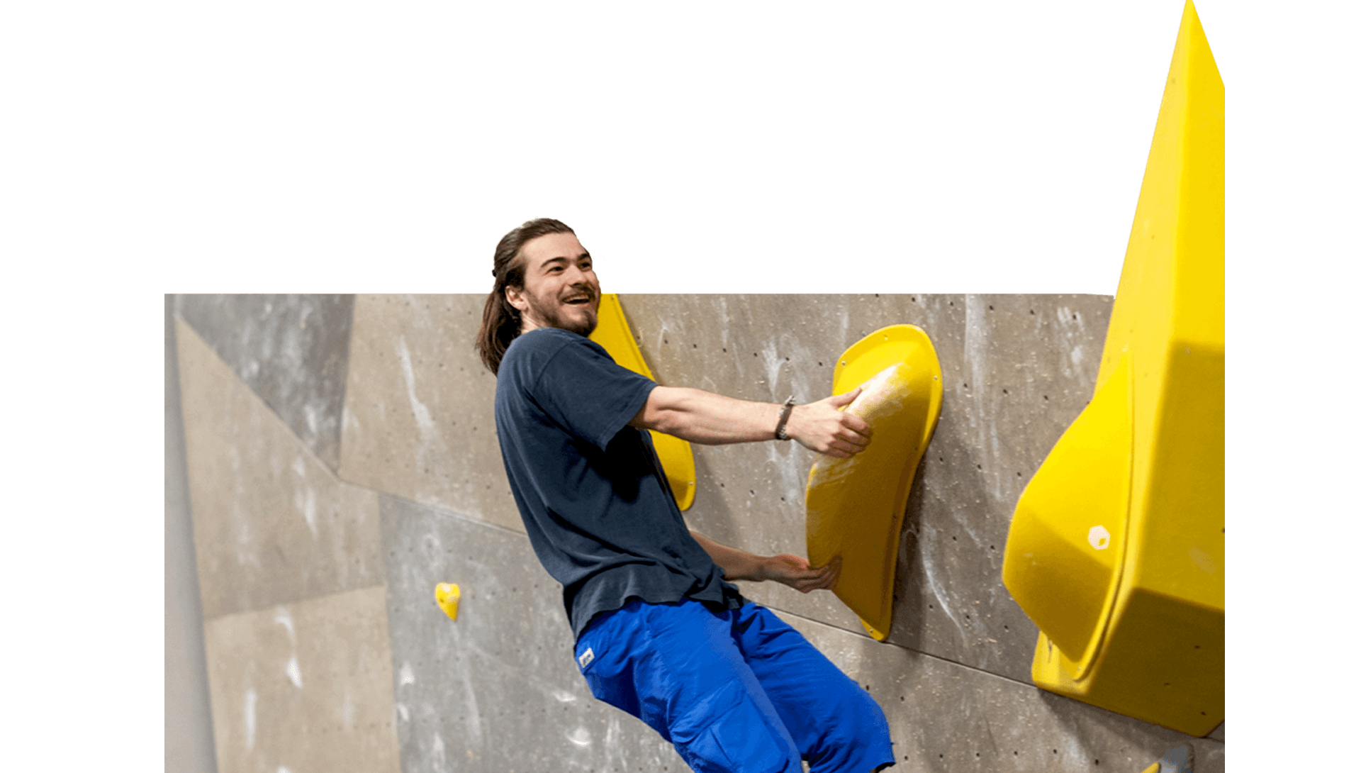 Grimpeur souriant qui attrape une prise de bloc jaune